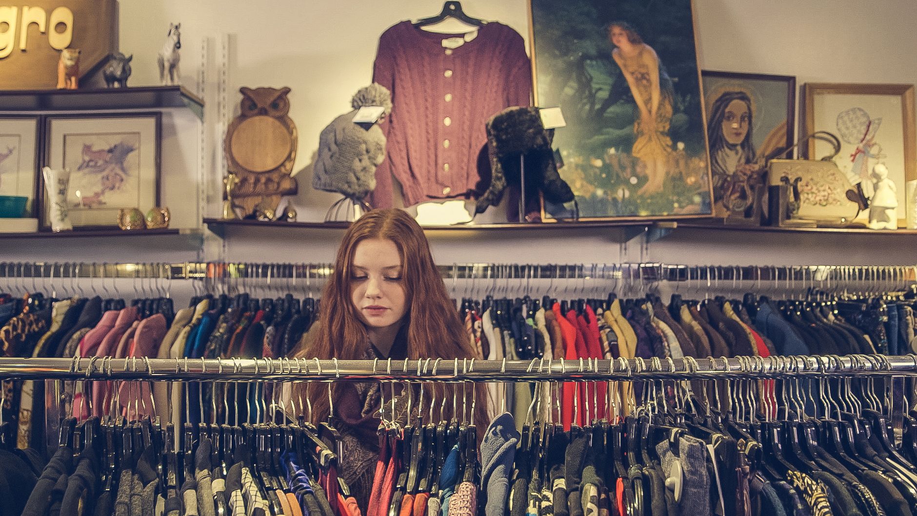 Warm, organized interior of a small thrift and boutique shop with clothing racks