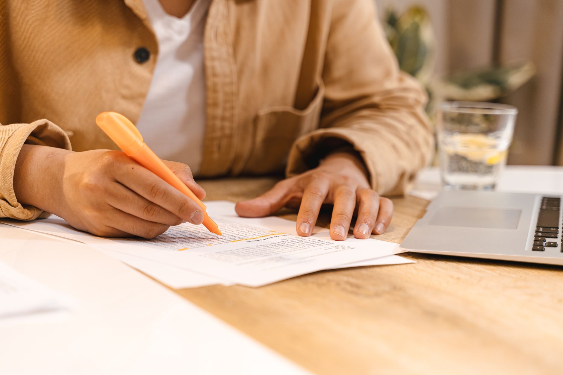 A buyer reviewing a lender's loan estimate with a highlighter and laptop